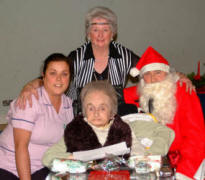 Christmas came early for Thompson House resident Shirley Woodburn on Saturday 2nd December at the Senior Members� Christmas Tea in Railway Street Presbyterian Church.  Shirley is pictured after receiving a gift from Santa (Ian Barron) and Santa�s helper (Norma Coggins).  Included in the picture is Sharon Grier (Nursing Auxilary).