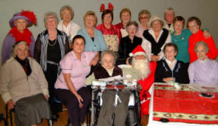 Thompson House resident Shirley Woodburn, Nursing Auxilary Sharon Grier and some ladies from Railway Street congregation are pictured after receiving their gifts from Santa (Ian Barron) and Santa�s helper (Norma Coggins) at the Senior Members� Christmas Tea in Railway Street Presbyterian Church on Saturday 2nd December.
