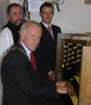 The Rector, the Rev Tom Priestly and organist Alan Yarr look on as the Mayor, Councillor Trevor Lunn, re-takes the seat at St Colman's church organ which he occasionally occupied during the period when his father sang in the church choir.