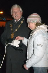 The Mayor, Councillor Ronnie Crawford looks on as Erin Mulholland switches on the Christmas tree lights.