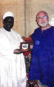 HRH Ufuwai Bonet, Chief of Kagora receives a plaque from local man David Savage on behalf of Lisburn City Council.
	
