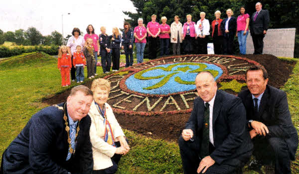 Mayor of Lisburn, Alderman Paul Porter ls pictured with Mrs Iris Andrews, South Antrim County of Girlguiding UK; Councillor James Tinsley, Chairman of the Council's Environmental Services Committee and Mr Robert Hamilton, Lisburn City Council's Parks Supervisor. In the background members of the local Girtguiding association admire the floral display.