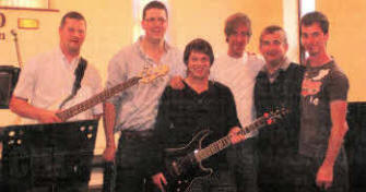 Maghaberry Elim pastor, Mr Brian Madden, second from right, welcomes the well-known Gospel rock band lnflame to the church for a concert to mark the finale of the fellowship's highly successful summer schemes.