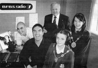 Orla, Rebecca and outgoing Mayor, Councillor Trevor Lunn are welcomed to the BFBS Lisburn station by presenters Eddie Castle and Johnny Ferguson.
