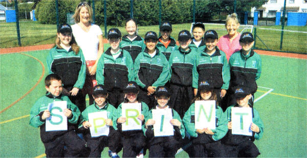 Children from Finaghy Primary School with teachers Ruth White and Annalisa Flanagan, who are wearing team track-suits and specially designed caps with the project's SPRINT logo at SportsZone.