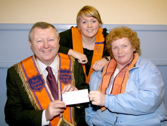 District WM of Down Women�s District LOL No 4, Sister May Dickson, Treasurer of Corbet Accordion Band is pictured presenting a cheque for �300 to Bro Drew Nelson (Secretary - Grand Orange Lodge, Ireland) for forwarding to the Lord Enniskillen Memorial Orphan Society. Looking on is band chairperson, Sister Alicia Dickson, of Star of Dromore Women�s LOL 66. The money was raised at a BBQ at Corbet Orange Hall when a gift was auctioned to raise funds for the charity.