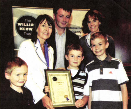 William Keown Trust president Kate Smith hands over the Child of Courage certificate to Patrick McCann. Looking on are proud parents Patricia and William and brothers Jack and David.