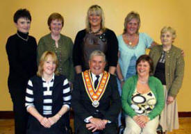 The Most Worshipful Robert Saulters (Grand Master) pictured with ladies who served supper at a meeting marking the centenary of Whitehill Orange Hall. L to R: (seated) Lily MacRoberts and Karen MacRoberts. (back row) Sally McCahon, Ann Woods, Cheryl McRoberts, Anthea MacRoberts and Josie MacRoberts.