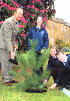 The Marquis of Downshire with Gailmarie Milligan, Victoria Tannahill and Christopher Kane from Beechlawn School in Hillsborough planting a tree in the Castle grounds to replace the one planted in 1872 by his Great Grandfather