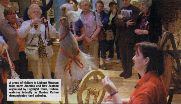 A group of visitors to Lisburn Museum from north America and New Zealand organised by Highlight Tours, Dublin, watches intently as Davina Callen demonstrates hand spinning.