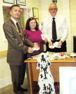 Dale Carson - President, Lagan Valley Rotary, Roisin McGarry Receptionist LHC and Mr David Parkinson Lisburn Hearing Centre sort through the many hundreds of used stamps already received.