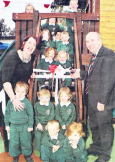 Mrs Clare McAllistair, nursery teacher, and Mr Patsy McClean, principal, cutting a ribbon to open the new outdoor play area at St Aloysius Primary School, Lisburn.