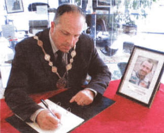 Lisburn Mayor James Tinsley signs the Robert Dunlop book of Condolence at the Island Centre.