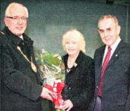Councillor Allan Ewart (Mayor) presents Pearl Finn (Secretary of Hillsborough Old Guard) with a bouquet of flowers in recognition of her work in the publication of the book . Looking on is Harry Shorn (Chairman of Hillsborough Old Guard).