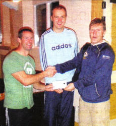 Handing over the cheque for £15O for the IFA Going For Goal Charities is Matt Peach from Logic Café to man of the match Ian Stewart with game organiser Stuart McKinley (centre). US37O9-Going for Goal 2