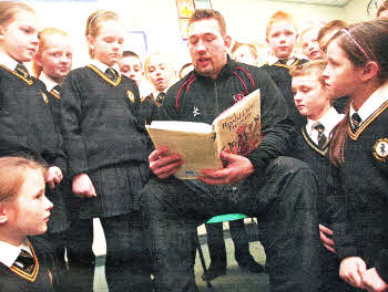 Ulster Rugby Star Justin Fitzpatrick reads to pupils in Christ The Redeemer as part of an initiative to get boys reading. US4709-121A0