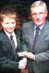 Scott Oswell received an SEELB award for outstanding achievement for overcoming many medical difficulties whilst at Tonagh Primary School. Presenting the award is Stanton Sloan, chief executive of the SEELB. US4809-111A0