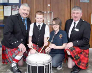 Adam McBratney and Emma Sands from Upper Crossgare Pipe Band are pictured with Kenny Crothers - RSPBA NI Treasurer (left) and Alex Gordon - RSPBA NI Vice Chairman (right).