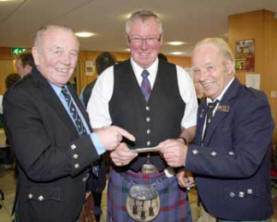 Fred Walker - RSPBA NI President (left) points out the next item on the programme to RSPBA NI Stewards - Edmond Montgomery and Jeff Butcher.