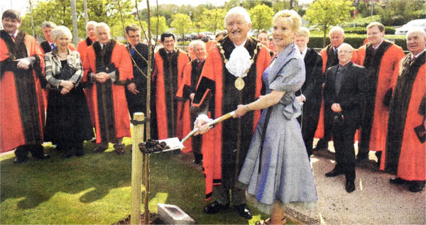 Mayor Councillor Ronnie Crawford planting a tree after the ceremony in Lagan Valley Island. Also pictured are members of Lisburn City Council, along with Mrs Joan Christie, Lord Lieutenant of Antrim.