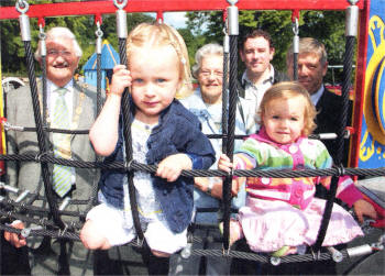 Ellie Fogarty and Sarah Joy Mullan enjoy one of the many play areas in the refurbished Hilden Play Park. Looking on are the Mayor of Lisburn, Councillor Ronnie Crawford; Mrs Elise Coburn from Coates Barbour Trust; Chairman of Hilden Community Association, Mr Barry Donaghy and Chairman of Lisburn City Council's Leisure Services Committee, Councillor Brian Heading.
