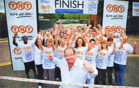 TNT UK Regional Managing Director Tom Bell, centre, joins the Belfast TNT runners on the finish line on their 'Running on Empty' marathon relay challenge