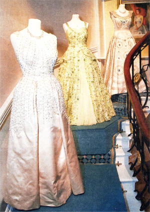 A collection of formal ensembles which have been worn by Her Majesty the Queen at state occasions go on display at Hillsborough Castle throughout the month of August. The dress in the foreground was worn by the Queen for a portrait by Karsh, from Canada, while the dress at the top of the stairs was worn by the Queen during a state visit to the USA in October 1957. US3009-542cd