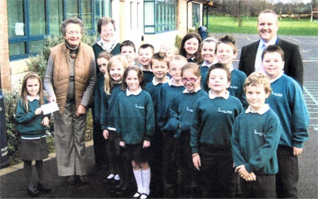 Pupils of Meadow Bridge Primary with Principal, Mr Paul Good, present Mrs Mary Donnelly and Ms Elizabeth Hendron, committee members of the Lisburn Branch of Save the Children 