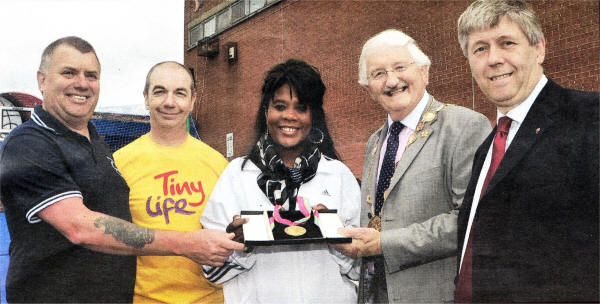 Ex-Olympian Tessa Sanderson, proudly shows her gold medal to Duty Officer of Kilmakee John Thompson, Ashley McKinley, Tiny Life Charity, the Mayor of Lisburn City Council, Councillor Ronnie Crawford and Chairman of Leisure Services Committee, Councillor Brian Heading.