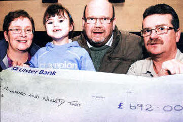 Diane and Bill Joss and daughter Heidi, who suffers from cerebral palsy, receive a cheque from Eddie Adams fright), representing the Lagan Valley Pigeon Club, which was used to help buy a Heidi a special needs bicycle. The money was raised by members of the Pigeon Club. US0110-538cd