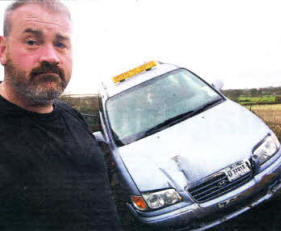 Jonathan Brown pictured beside his taxi which was damaged by a digger. US0510-102A0
