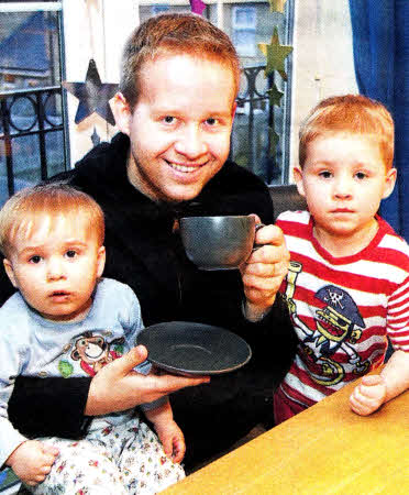 Richard McCrossan, from Lisburn, enjoys a well-earned cup of tea with sons Mathew, age 16 months, and Ben, age four, after a marathon 60-hour return journey across land and sea when volcanic ash flight cancellations left him stranded in Vienna. US1610-530cd