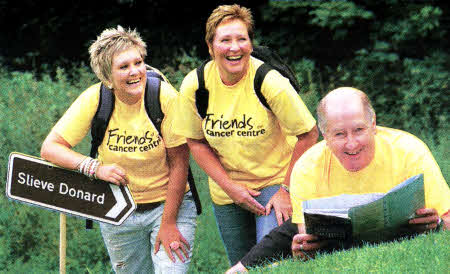 Lisburn's Gordon McKeown, Chairman of Friends of the Cancer Centre, is getting some walking and map reading advice in from previous participants Sarah Lynas (left) and her mum Lynne, ahead of the charity's forthcoming Slieve Donard Challenge on Saturday 11 September