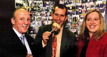 Environment Minister Edwin Poots samples Gourmet Fruit's caramel-coated apples at Lisburn Enterprise Organisation's 20th birthday celebrations. Gourmet Fruit, run by David Hallowell (left) is one of 1,350 businesses which the enterprise agency has helped to start up. Also pictured is Aisling Owens, the agency's Chief Executive.