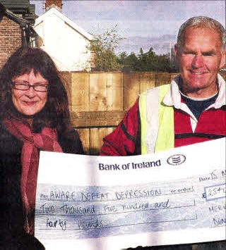 Alison Smyth from Aware Defeat Depression receives a cheque for £2540 from Mervyn Donaldson after he successfully climbed Kilimanjaro to raise money for the charity. 