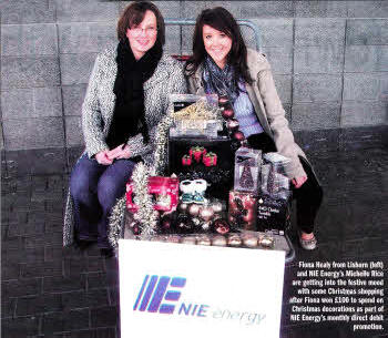 iona Healy from Lisburn (left) and NI Energy's Michelle Rice are getting into the festive mood with some Christmas shopping after Fiona won £100 to spend on Christmas decorations as part of NIE Energy's direct debit promotion.