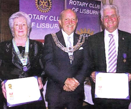 The Paul Harris Fellowships are presented to Norma Coggins and Billy Rogan by outgoing president of the Rotary Club of Lisburn, John Mcllroy.