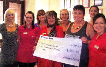 Staff of Mountvale who climbed Slieve Donard in Newcastle with the cheque for PSP
