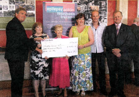 Ronnie, Helen and James Coulter present a cheque to Morina Clarke of Epilepsy Action Northern Ireland. (l-r) Jim Wells MLA, June Massey (chair of the Council of Management at Epilepsy Action), Morina Clarke, Helen Coulter, James Coulter, Ronnie Coulter.