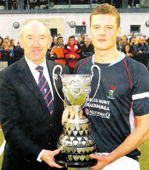 Ulster Hockey president Alan Morris presents Lisnagarvey captain Jonny Bell with the Kirk Cup, the oldest trophy in Irish hockey, following the Boxing Day final between Lisnagarvey and Cookstown at Comber Road. US5211-518cd