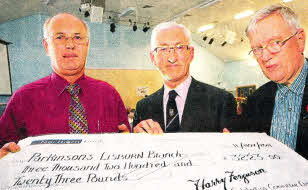 Harry Ferguson Celebration Committee members David Poots and Bill Forsythe handing over a cheque for £3,223 to Jim Henry, chairman of the Lisburn branch of the Parkinson's UK charity, during the annual Harry Ferguson lecture at Hillsborough. US4611-501cd