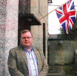 DUP MLA Jonathan Craig outside the house in the Oaklee Housing development where the resident wishes to fly the Union Flag.
