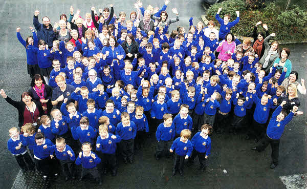 WE DID IT! Staff and pupils at Knockmore Primary School give a huge cheer after receiving the news they have all been waiting for - the school will not be closed. US4811.105A0 Pic by AIDAN O'REILLY