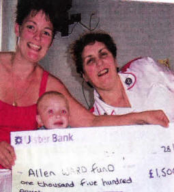 Lewis Walker with his mum Jennifer, presenting a cheque the Sister of the Alien ward at Royal Victoria Hospital