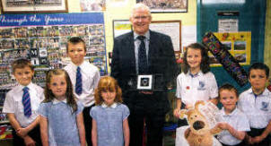 Maghaberry Primary principal David Taylor is presented with a grit by pupils on his retirement. US2611-108A0