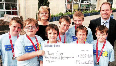 Vera Hewitt, Chairperson of Lisburn Hillsborough Fundraising group of Marie Curie Cancer Care, receiving a cheque for £352.60 from pupils of Riverdale Primary School who raised the money when they took part in the Lisburn Fun Run. Also pictured is Principal Trevor Carruthers. US2611-107AO