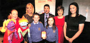 L-R Catherine Foreman from Action Cancer, with puppets Mambo and Jazz, UN's Tina Campbell, Ballinderry PS pupil Tom Hyde, Action Cancer Chief Executive Gareth Kirk, pupil Hannah Jones, teacher Lorraine Magowan and Jennifer Morton from Centra.