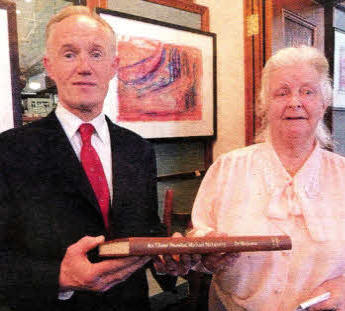 John Killen, Librarian, presents a bound copy of Margaret's thesis to her at the event on Monday.