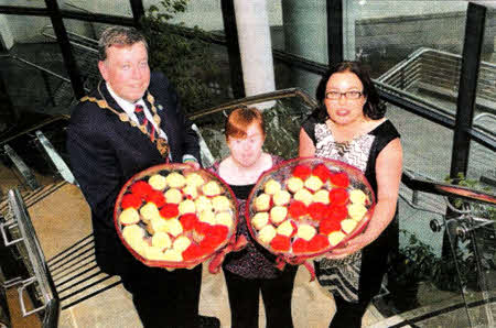 'Happy 13th Birfhday': Mayor of Lisburn, Alderman Paul Porter helps Stepping Stones trainee Rosie Scott and Chief Officer Paula Jennings celebrate the charity's 13th birthday at an event held in Lisburn's Civic Centre.