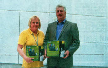 Paul Smith, Chairman of Pride of the Village Flute Band in Stoneyford, presents DVD players to a representative from the Royal Victoria Children's Hospital